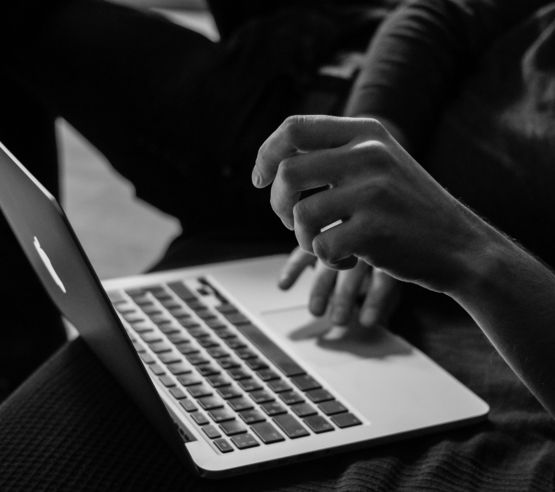 grayscale photo of person using MacBook